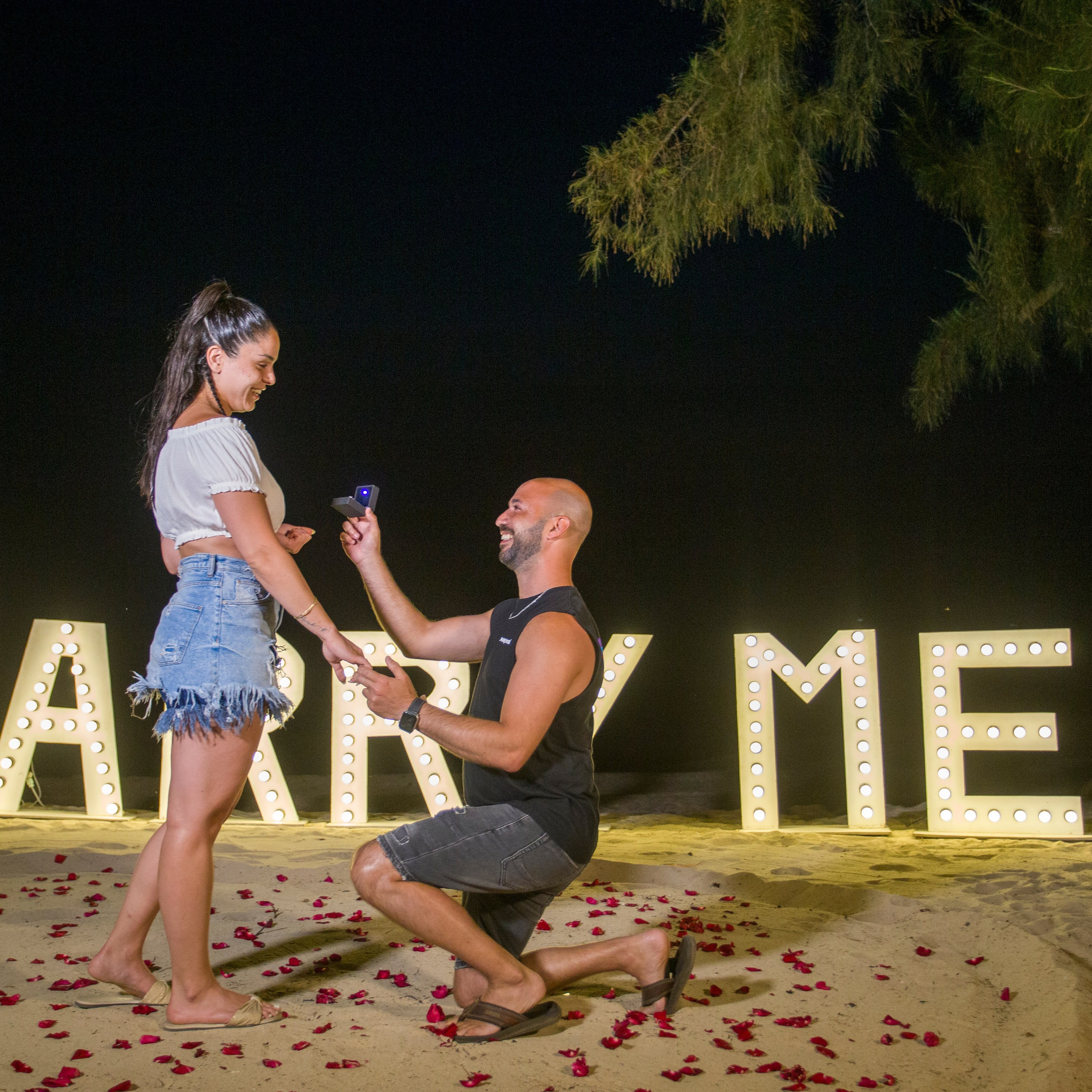Romantic beach proposal setup in Koh Samui with candles and flower arch.