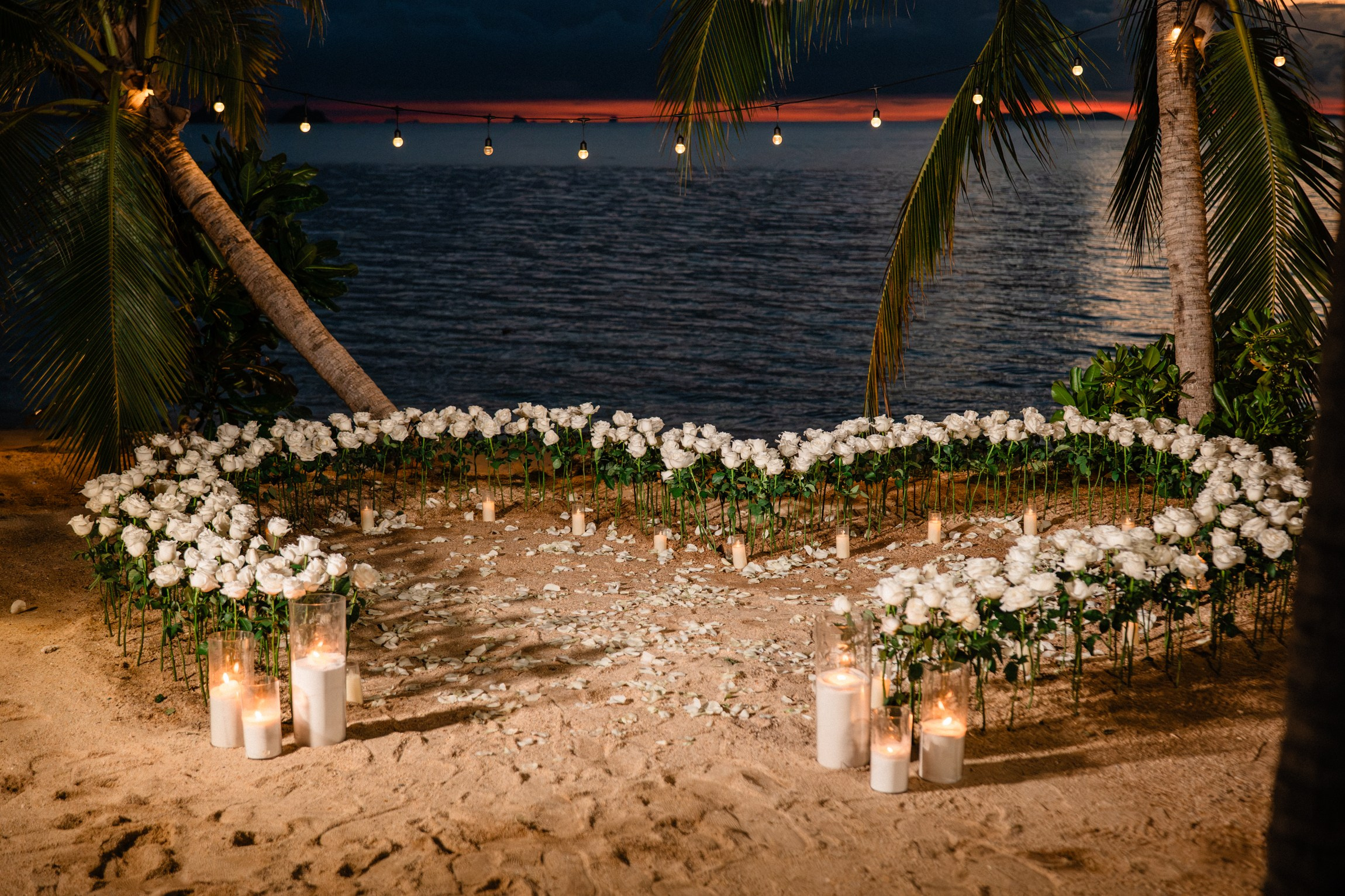 Luxury marriage proposal on a private beach in Koh Samui with flower decorations and romantic lighting.