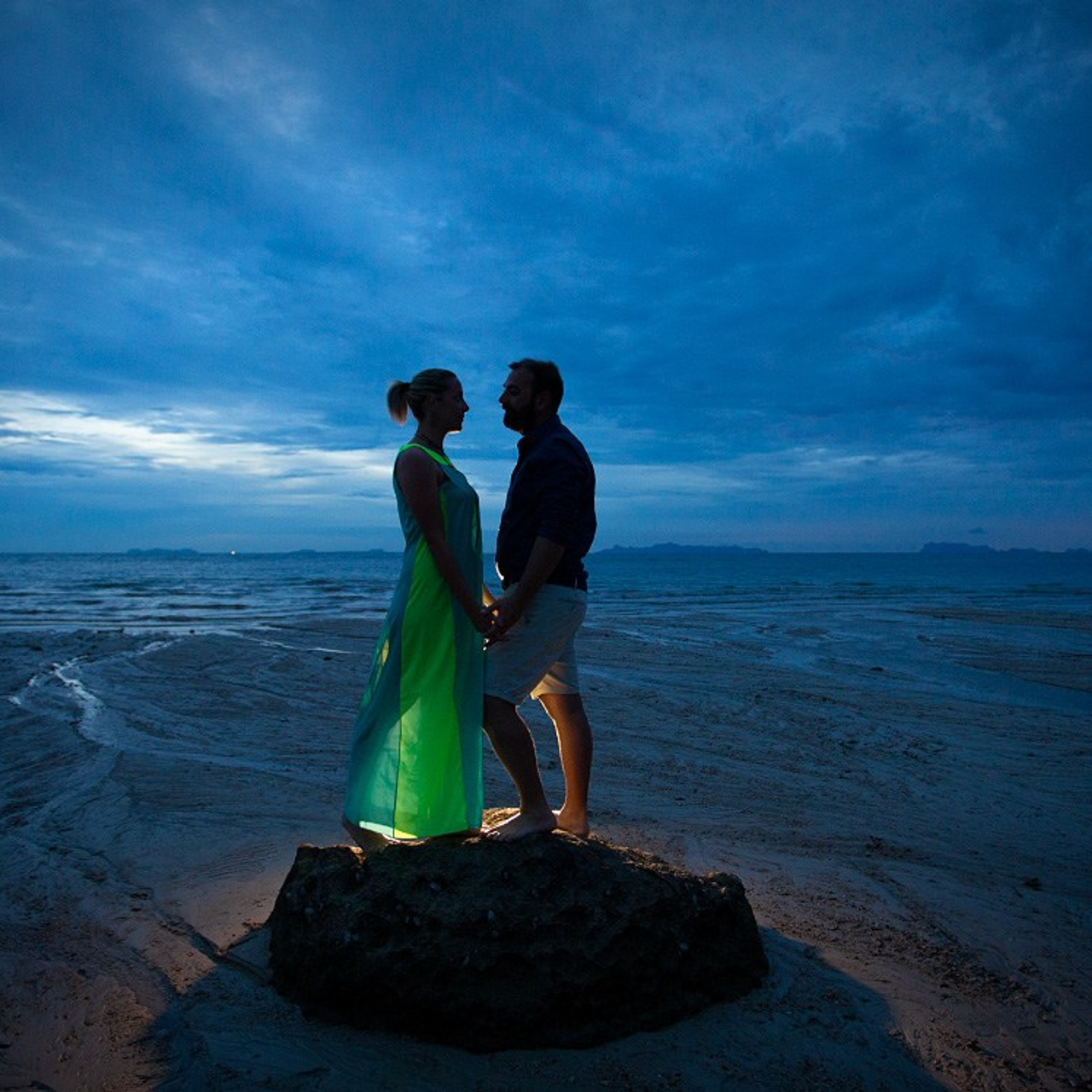 Romantic beach proposal setup in Koh Samui with candles and flower arch.