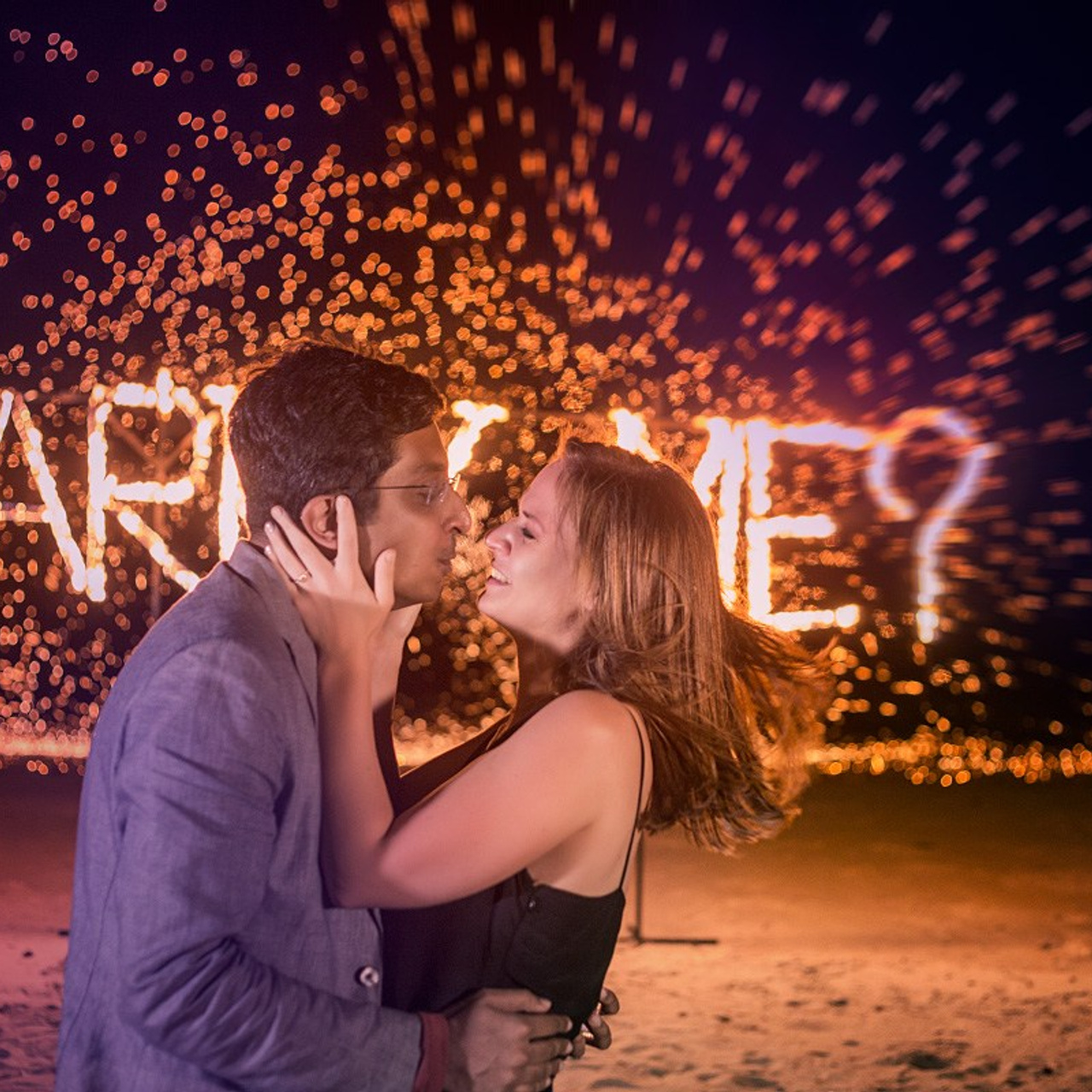Romantic beach proposal setup in Koh Samui with candles and flower arch.