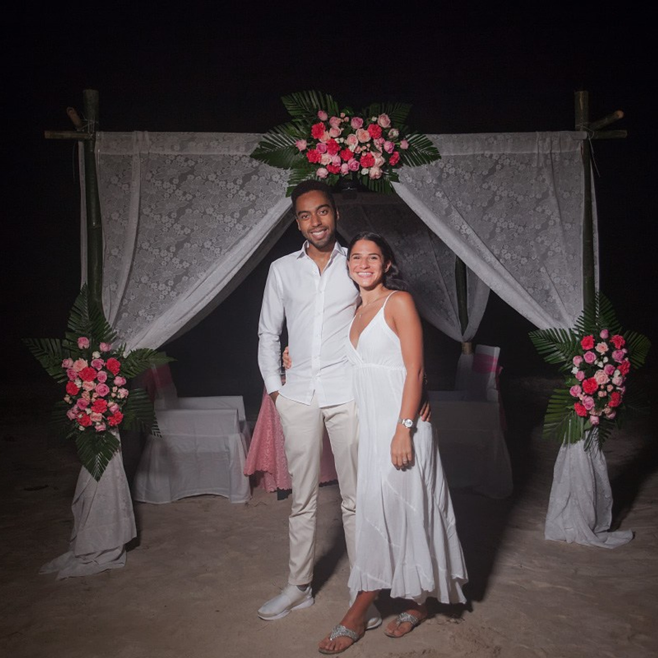 Romantic beach proposal setup in Koh Samui with candles and flower arch.