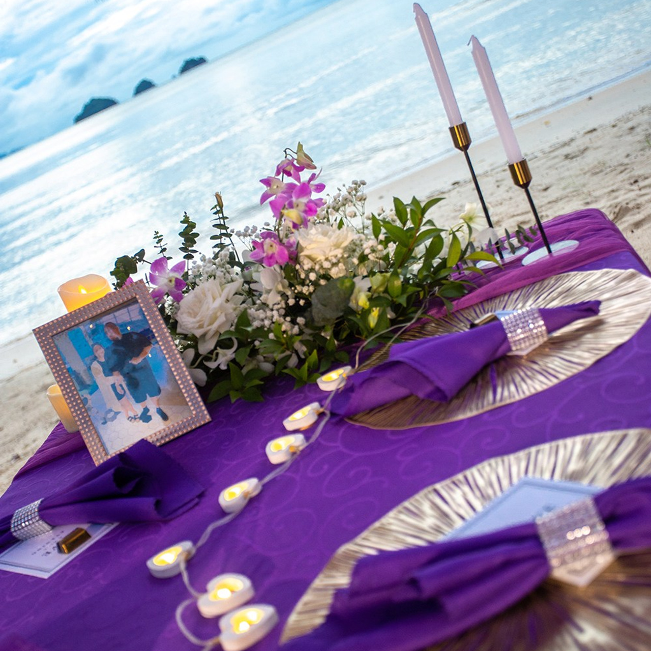 Romantic beach proposal setup in Koh Samui with candles and flower arch.