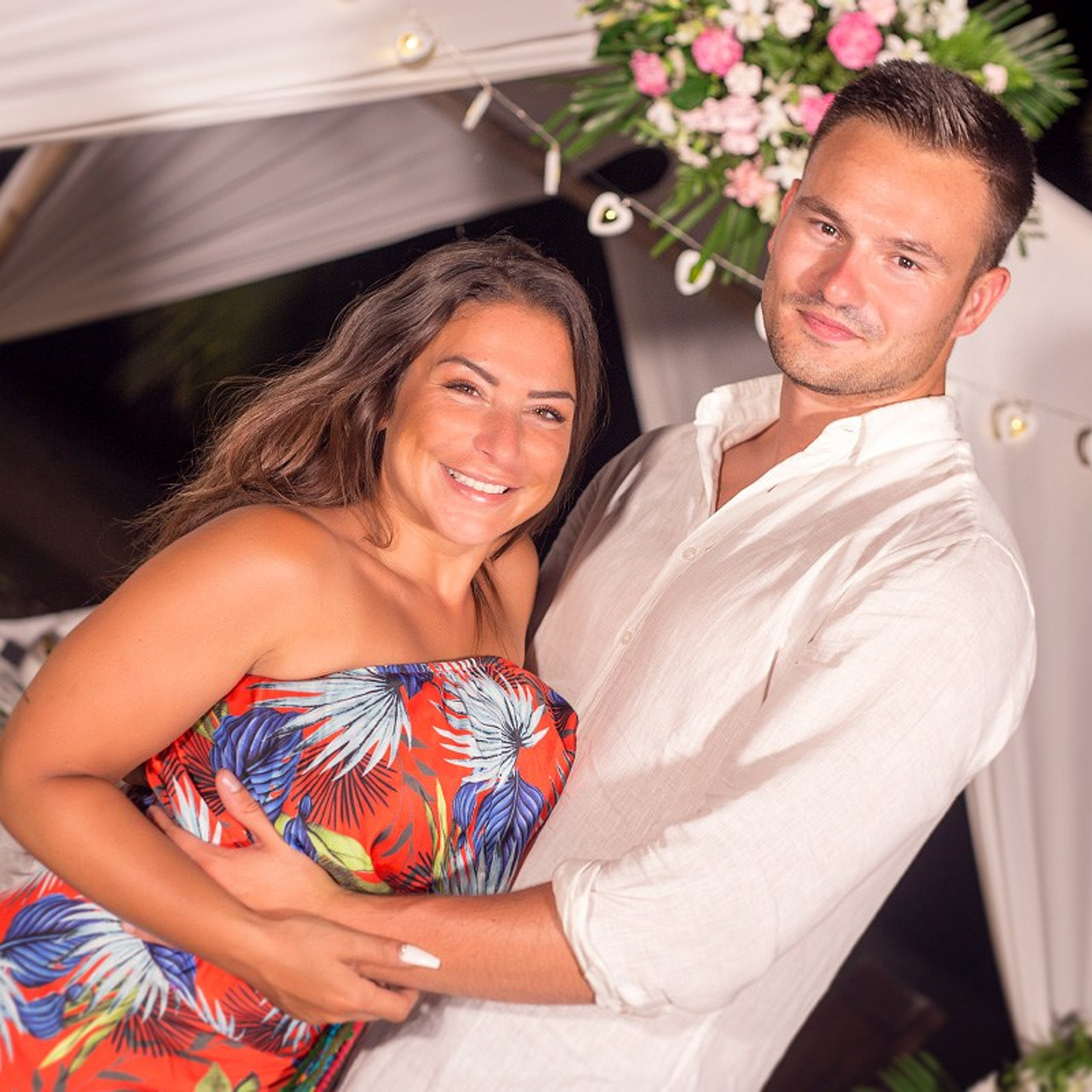 Romantic beach proposal setup in Koh Samui with candles and flower arch.