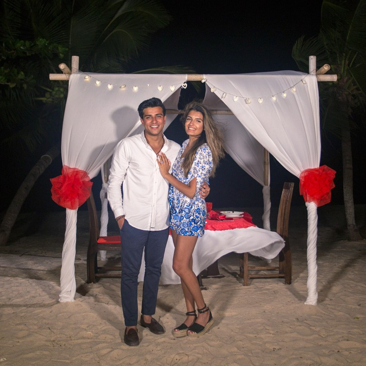 Romantic beach proposal setup in Koh Samui with candles and flower arch.