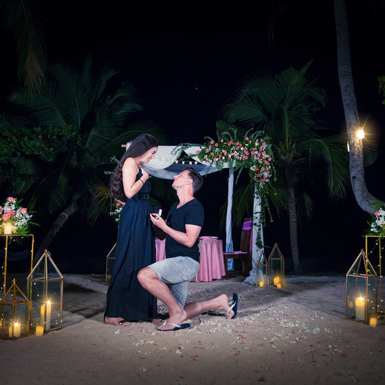 Romantic beach proposal setup in Koh Samui with candles and flower arch.