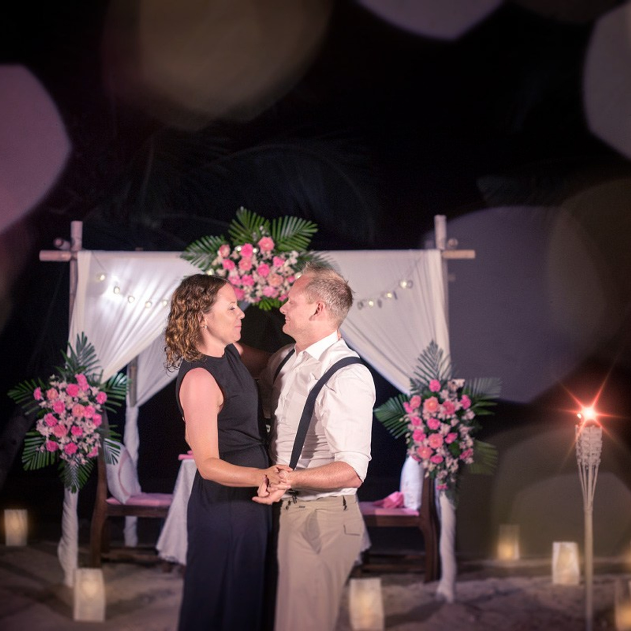 Romantic beach proposal setup in Koh Samui with candles and flower arch.