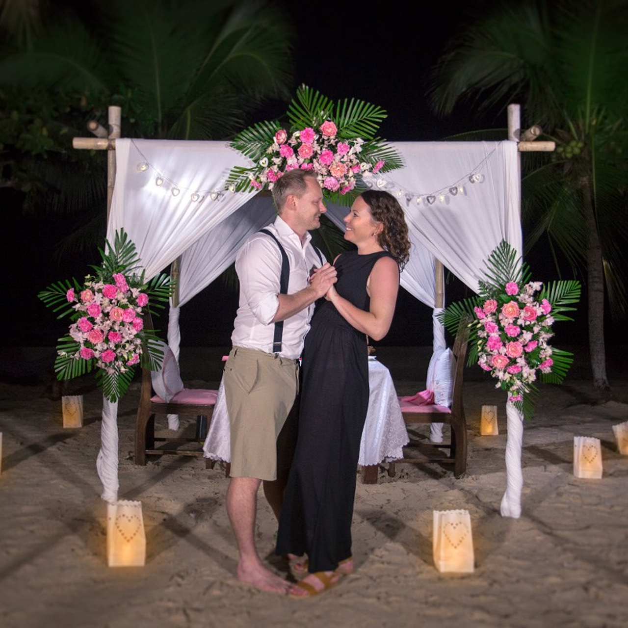 Romantic beach proposal setup in Koh Samui with candles and flower arch.