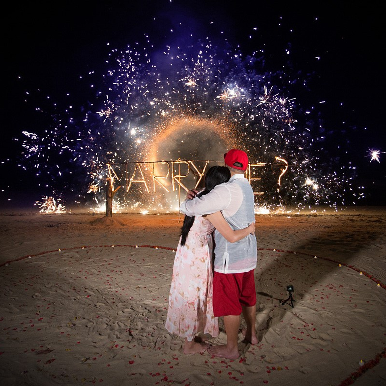 Romantic beach proposal setup in Koh Samui with candles and flower arch.
