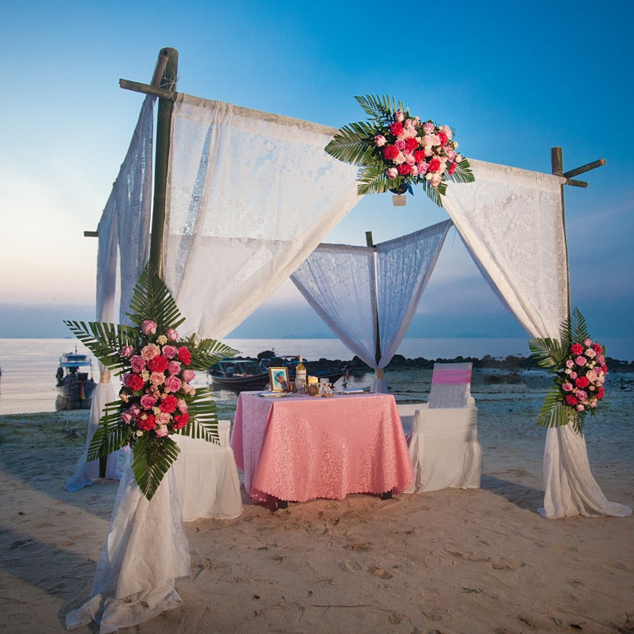 Romantic beach proposal setup in Koh Samui with candles and flower arch.