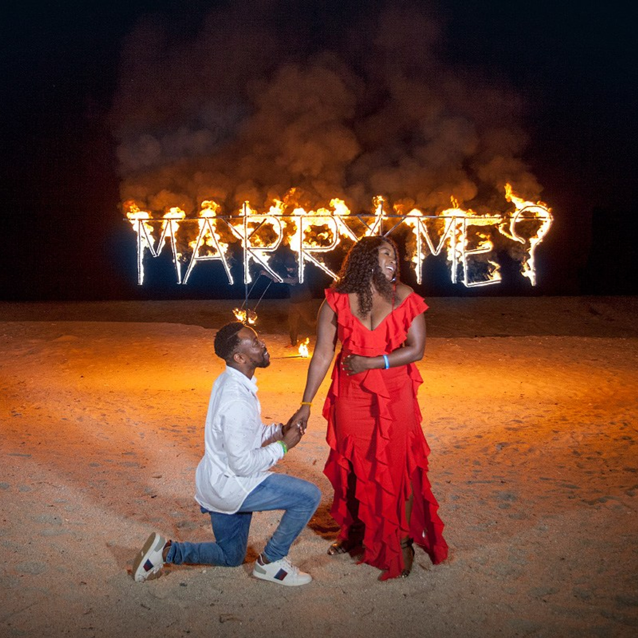 Romantic beach proposal setup in Koh Samui with candles and flower arch.