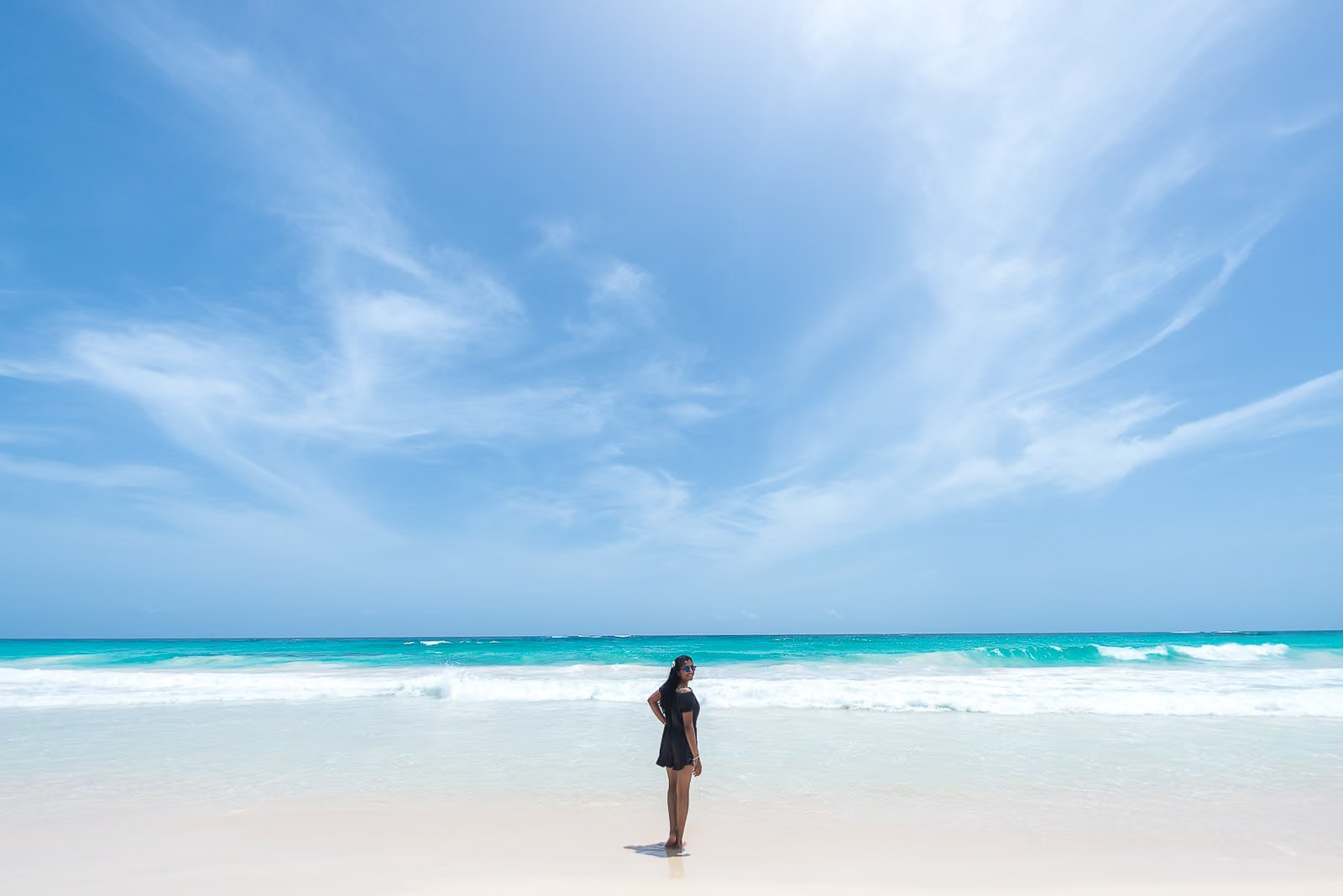 Woman on Bavaro Beach surrounded by white sand and the turquoise Caribbean Sea