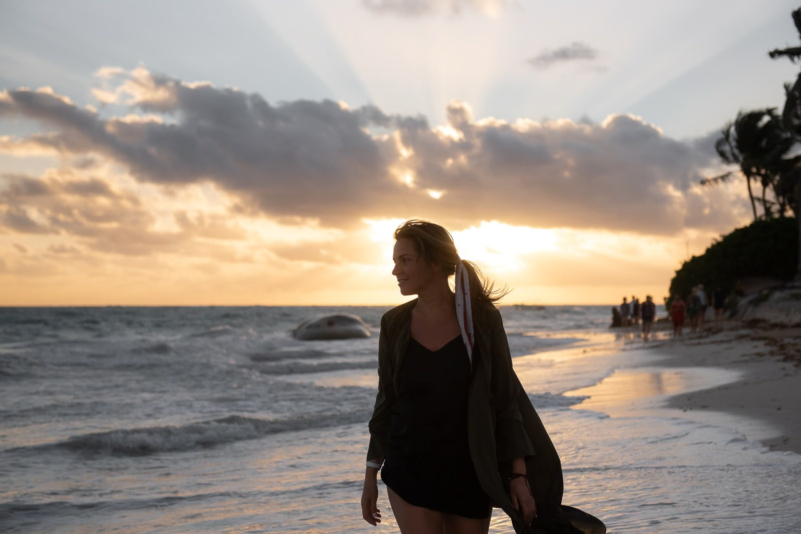 Woman walking along a Punta Cana beach with beautiful backlighting