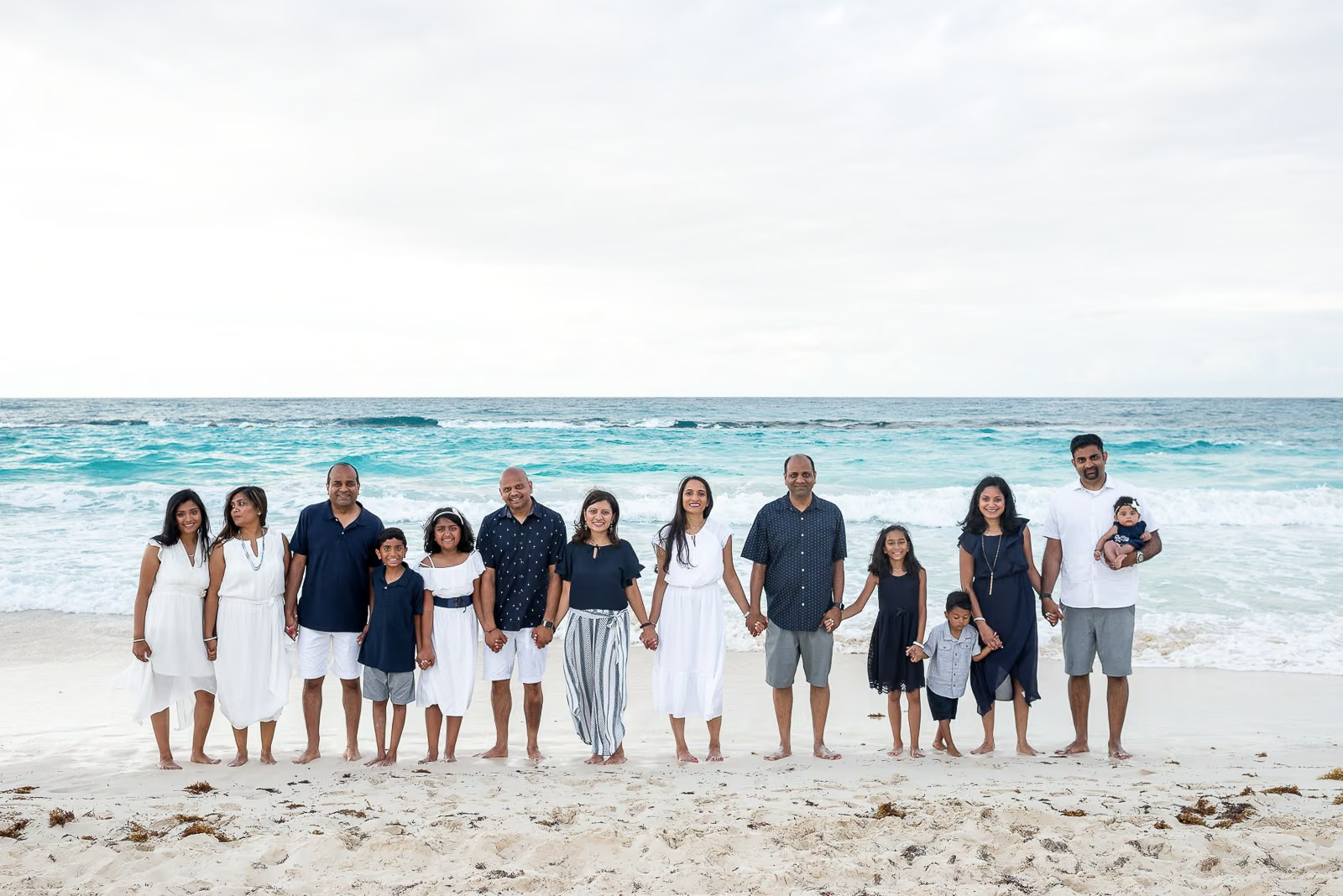 Retrato grupal de una familia grande de la India durante una sesión de fotos en la playa Bávaro en Punta Cana
