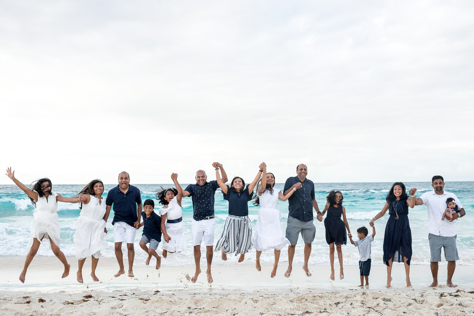 Foto divertida de toda la familia saltando en el aire durante una sesión de fotos en Punta Cana