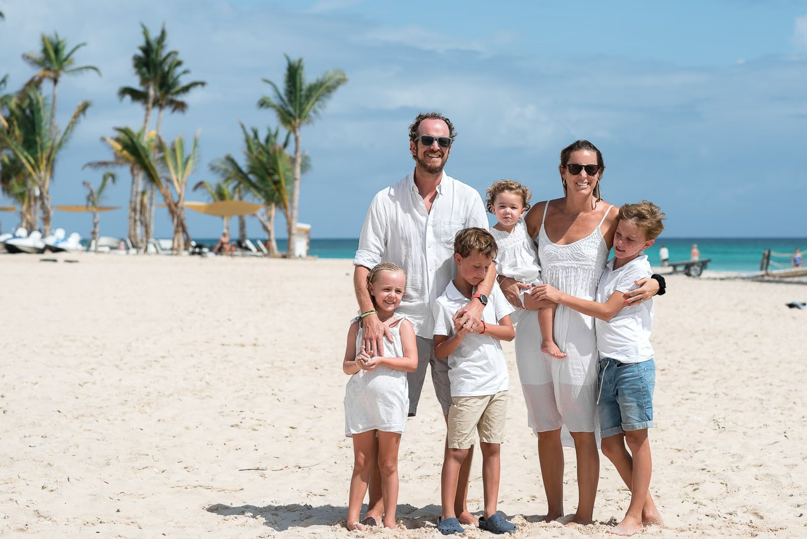 Smiling family with Caribbean ocean views during a Punta Cana family session.