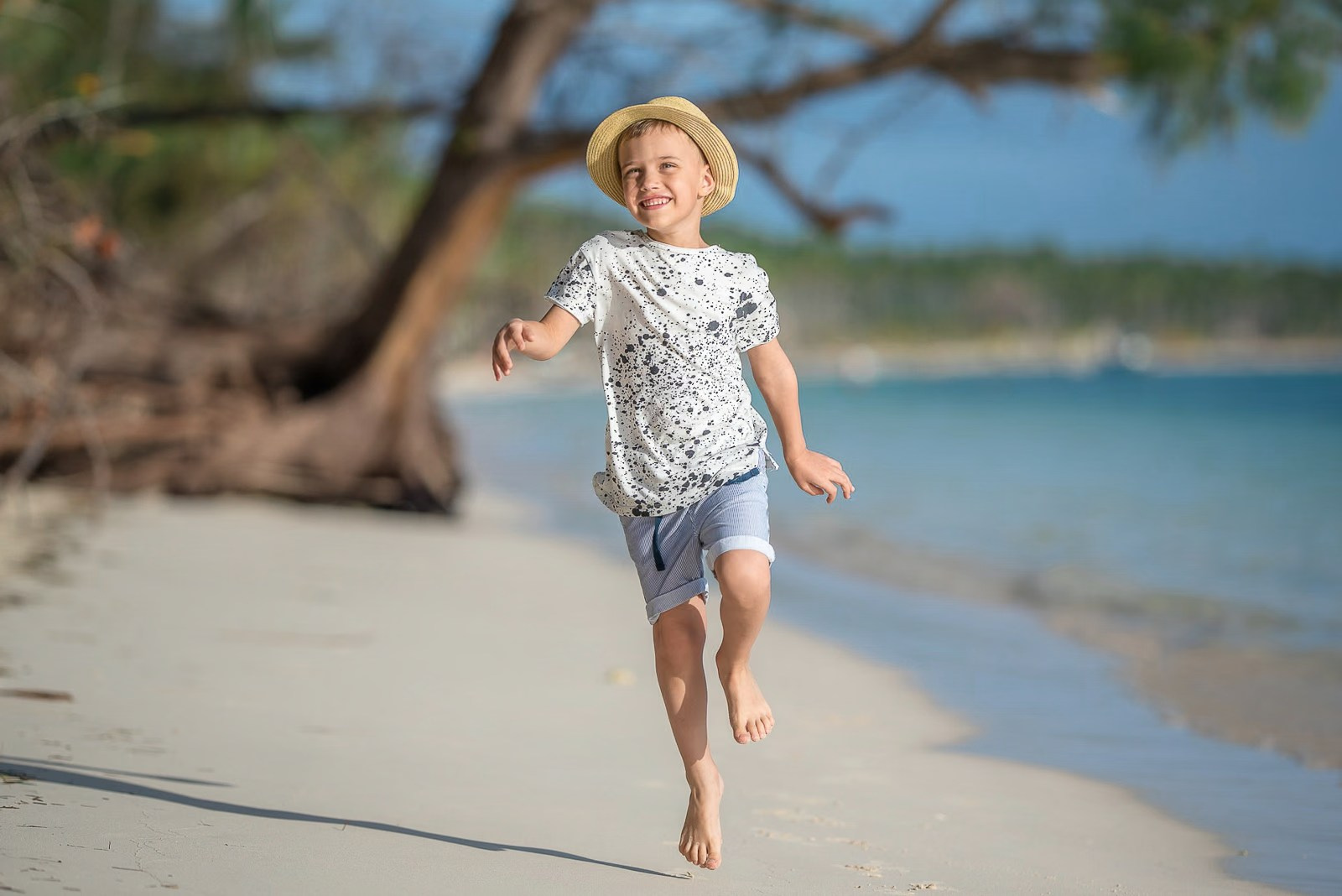 Happy boy jumping on the beach during a family photoshoot