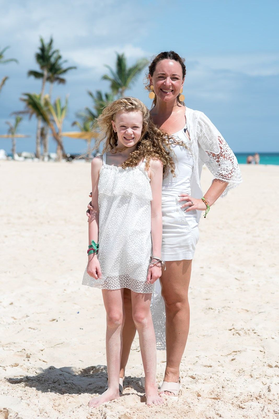 Relaxed family portrait with palm trees on Punta Cana beach.