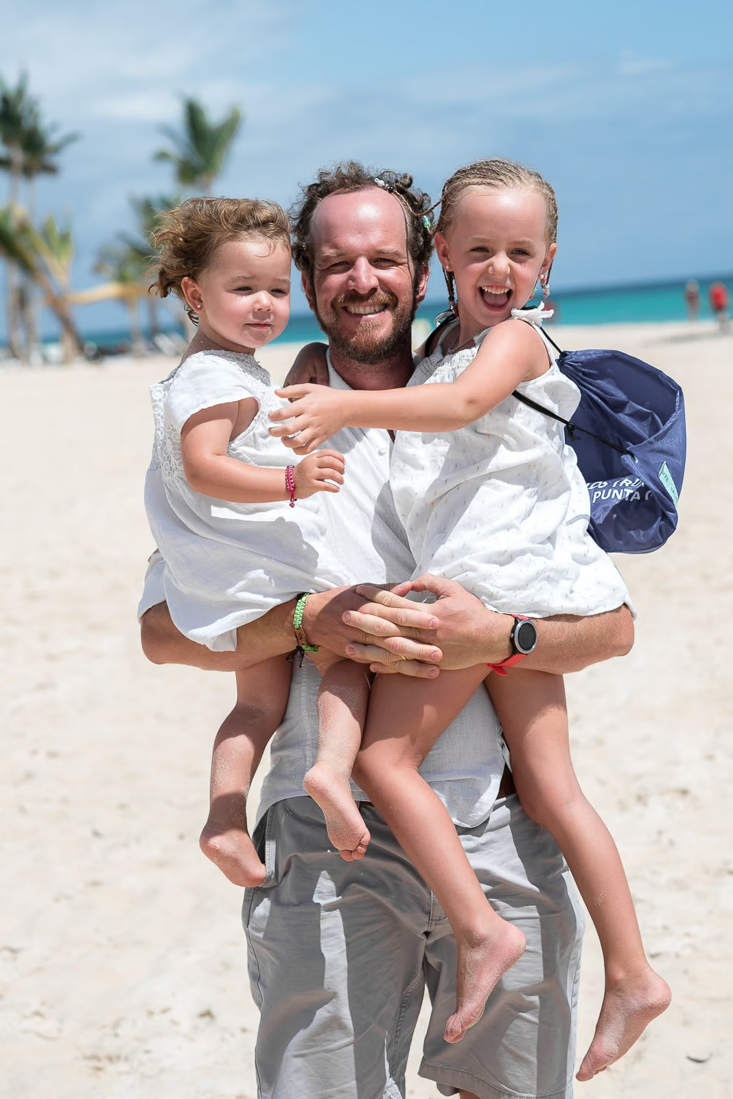 Joyful family beach photography session in Punta Cana with crystal clear water.