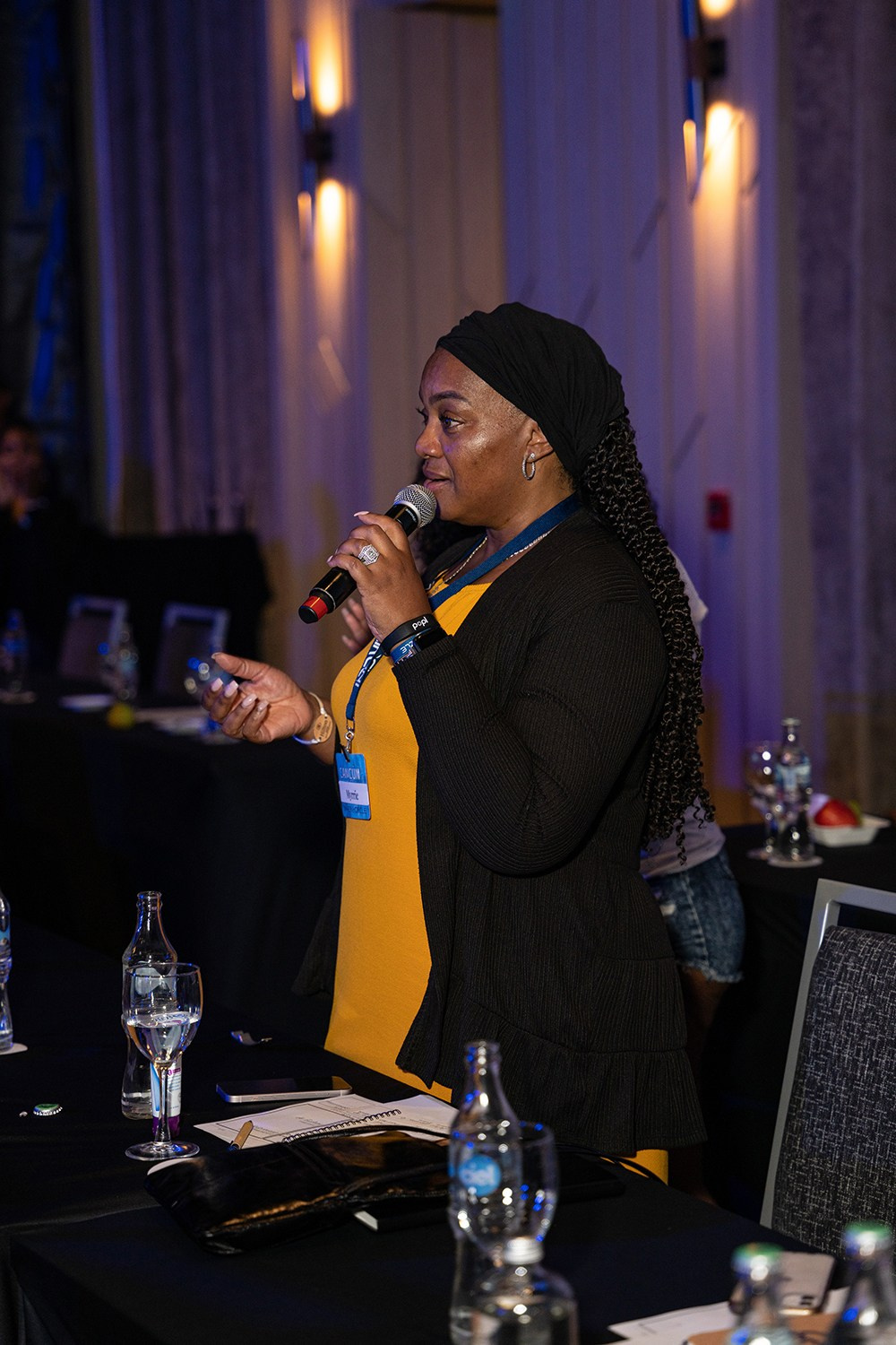 Attendee with microphone engaging speaker with detailed question.