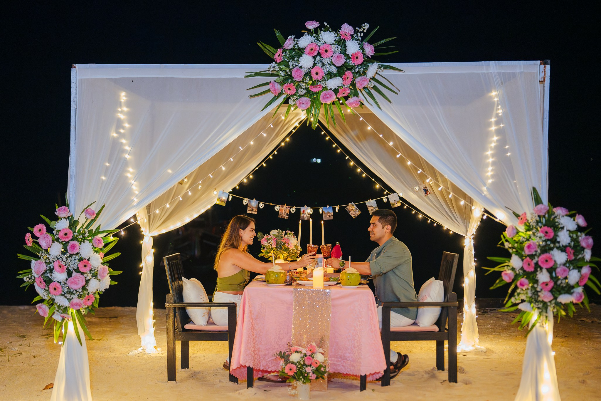 Romantic beach proposal setup in Koh Samui, Thailand with candles, flowers and ocean sunset view.