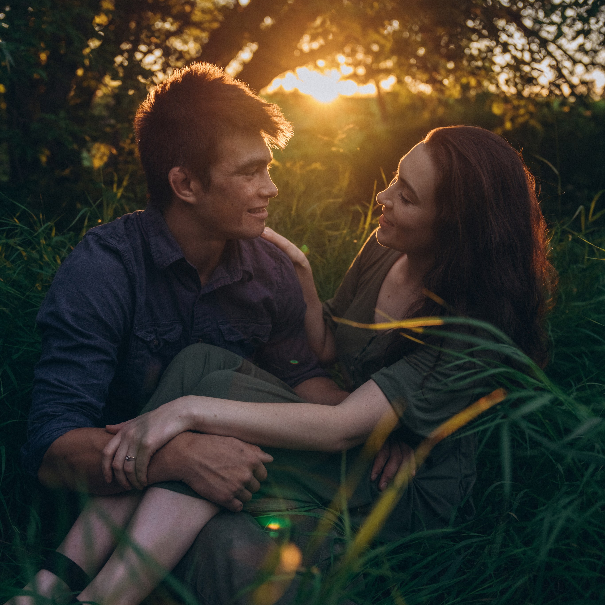 Loving couple sitting in the forest during sunset.