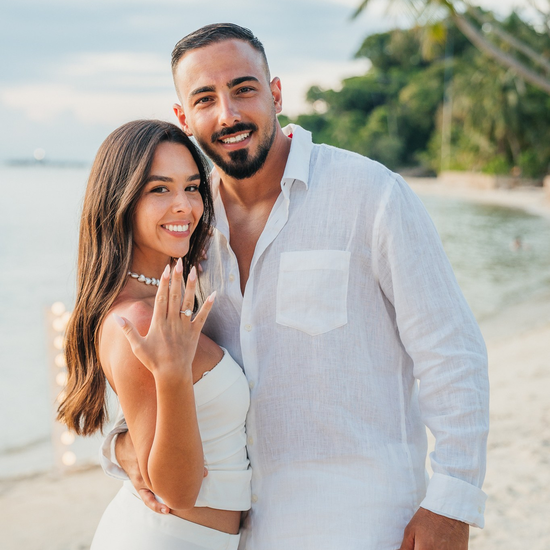 Romantic beach proposal setup in Koh Samui with candles and flower arch.