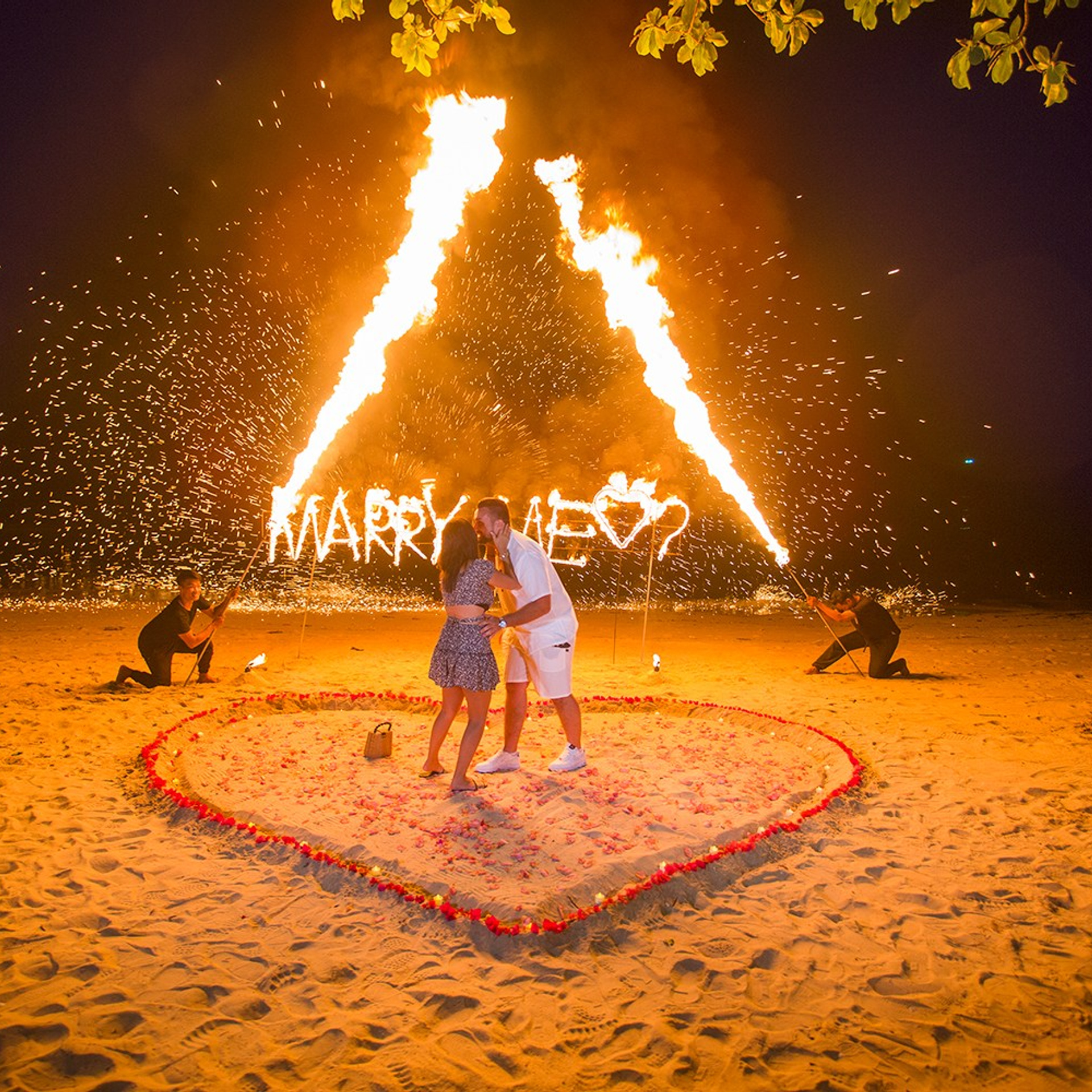 Romantic beach proposal setup in Koh Samui with candles and flower arch.