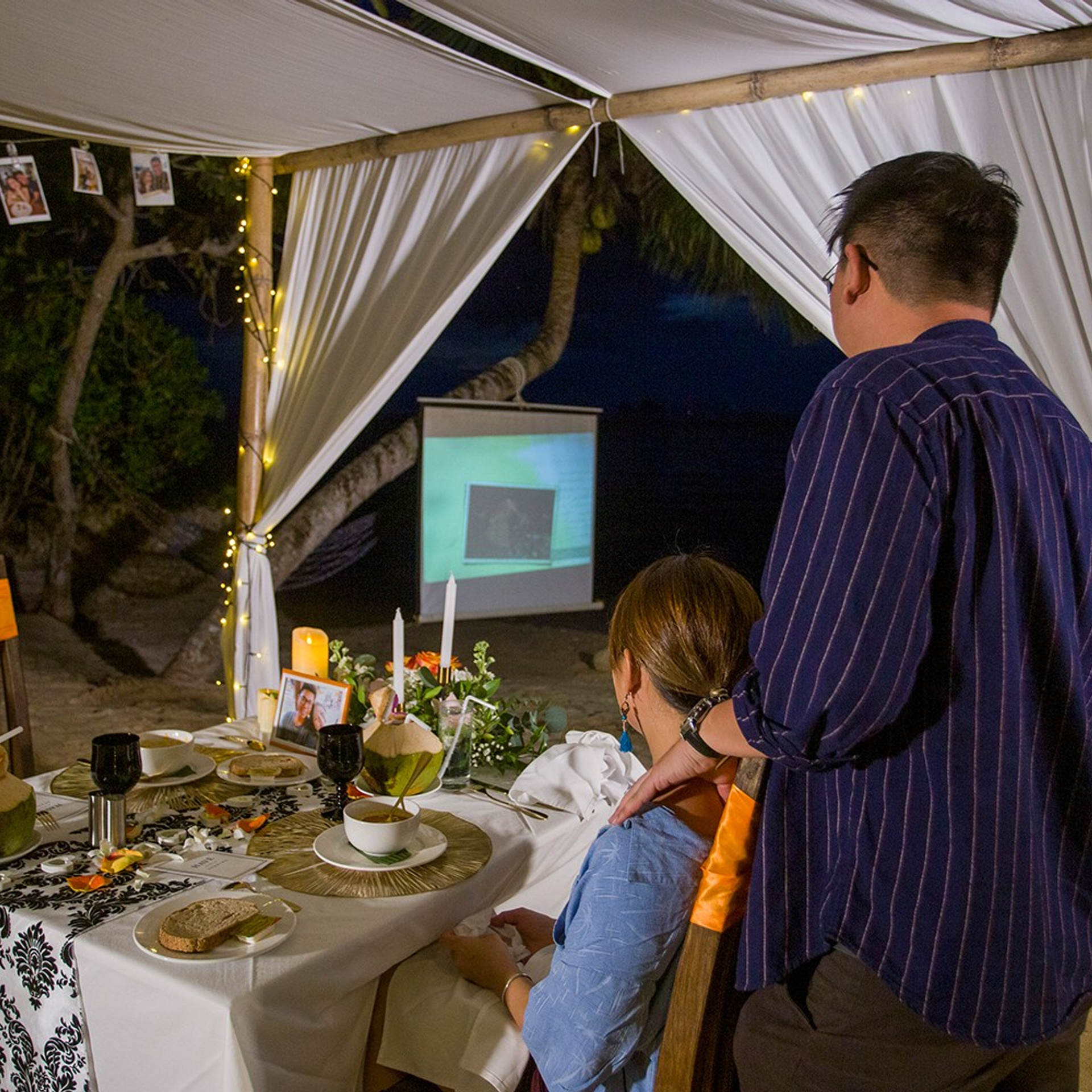 Romantic beach proposal setup in Koh Samui with candles and flower arch.