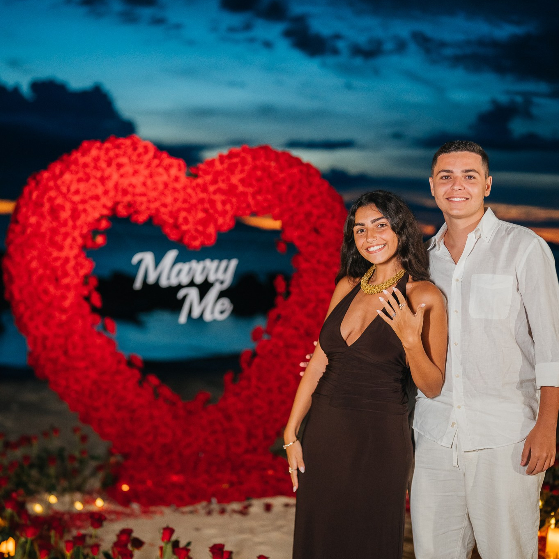 Romantic beach proposal setup in Koh Samui with candles and flower arch.