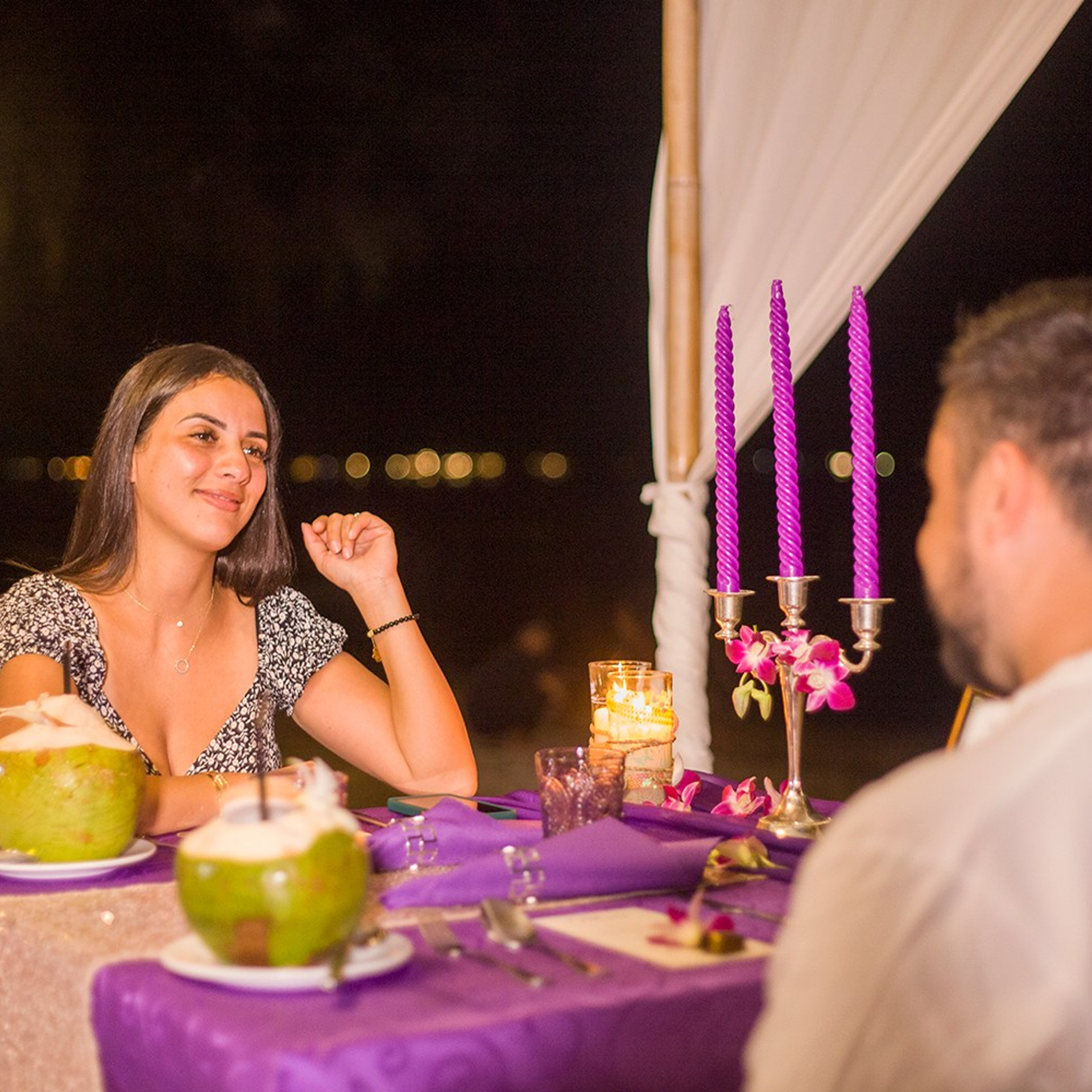 Romantic beach proposal setup in Koh Samui with candles and flower arch.