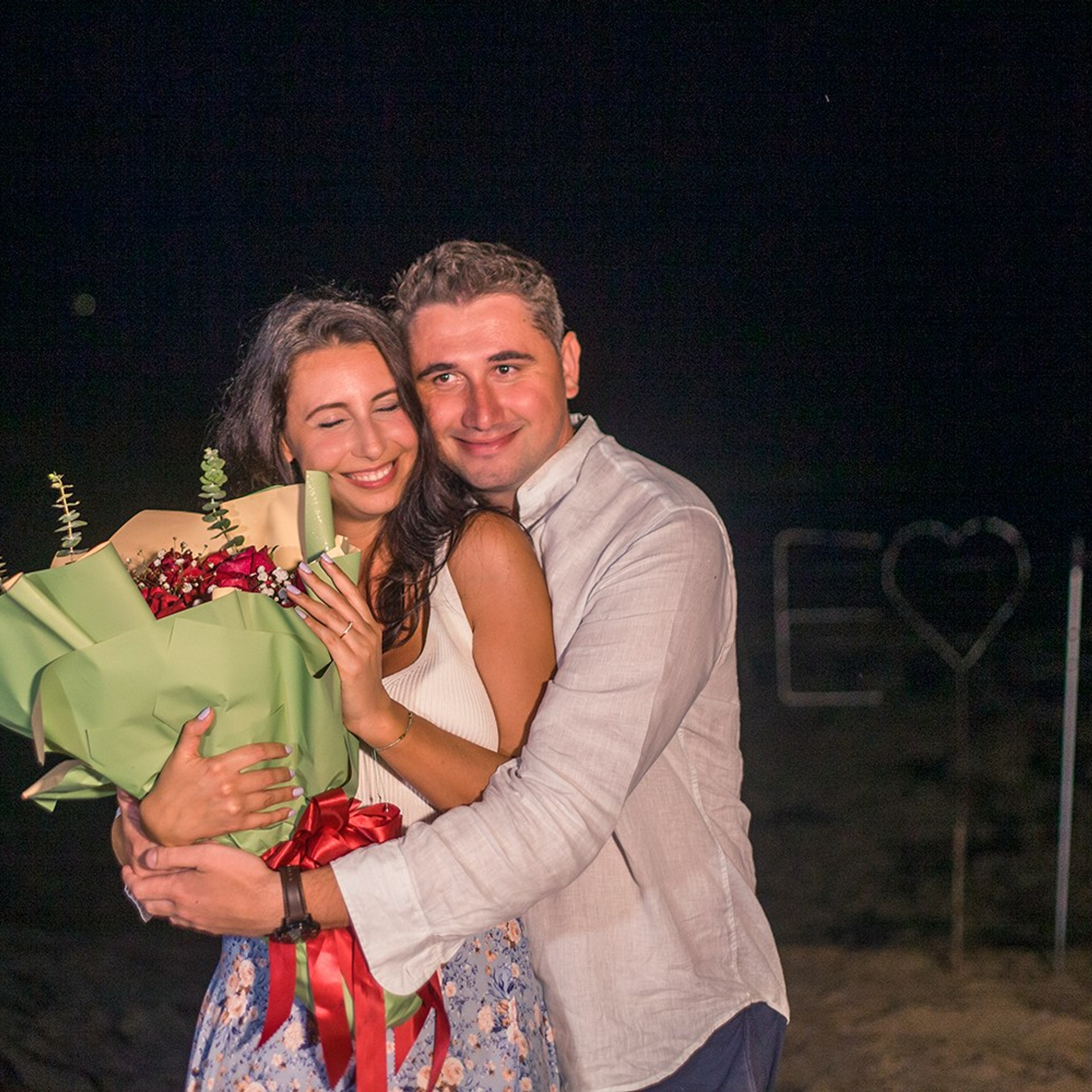 Romantic beach proposal setup in Koh Samui with candles and flower arch.