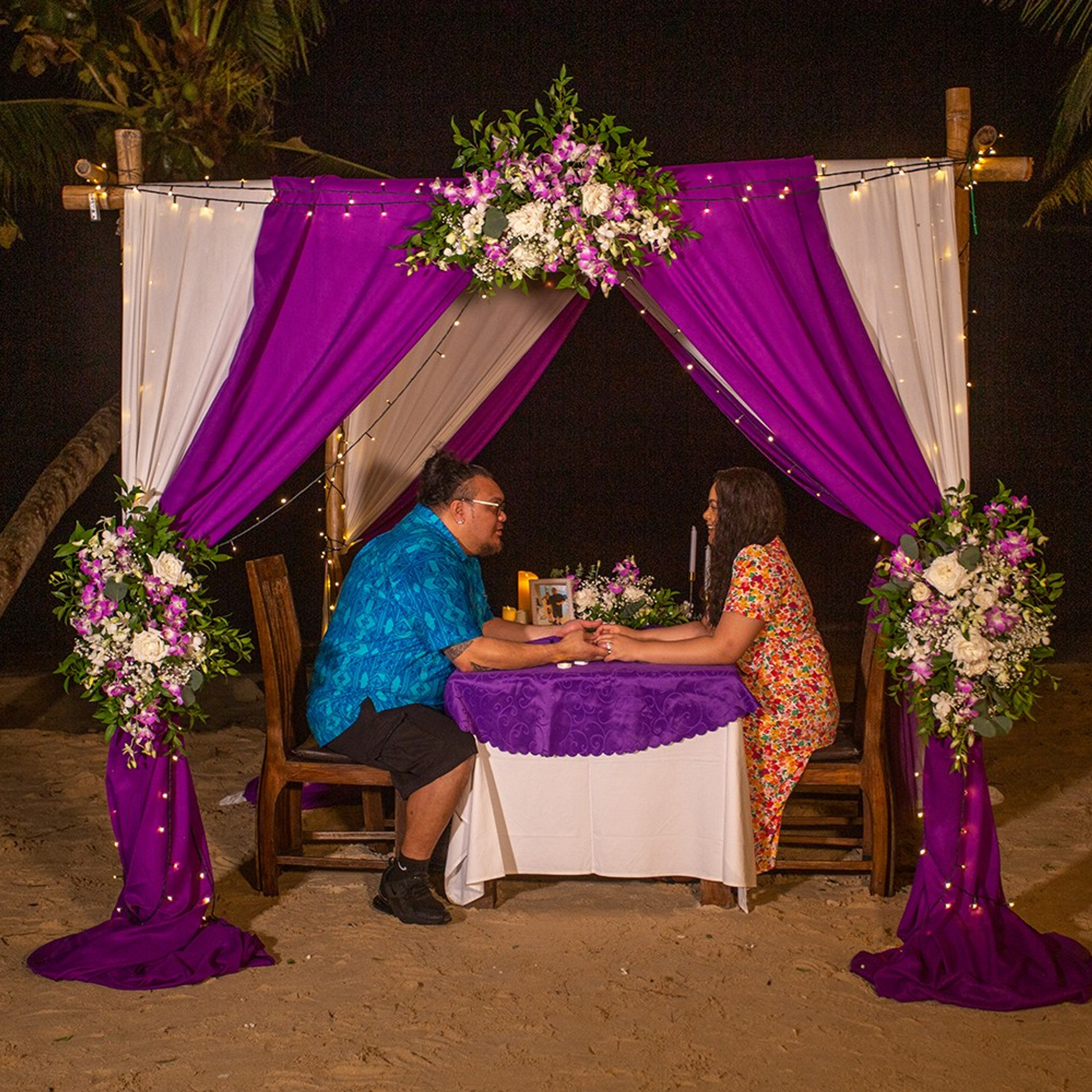 Romantic beach proposal setup in Koh Samui with candles and flower arch.
