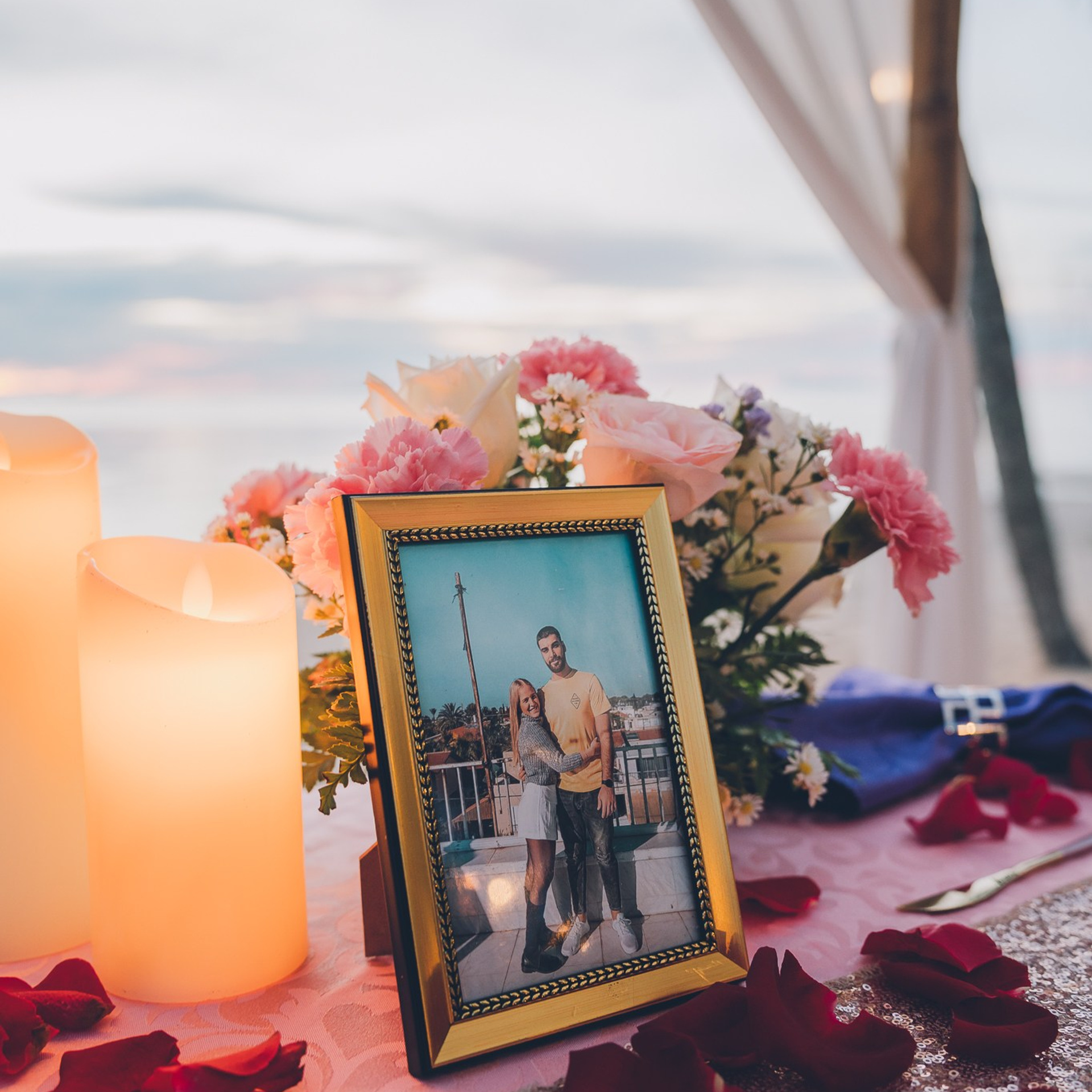 Romantic beach proposal setup in Koh Samui with candles and flower arch.