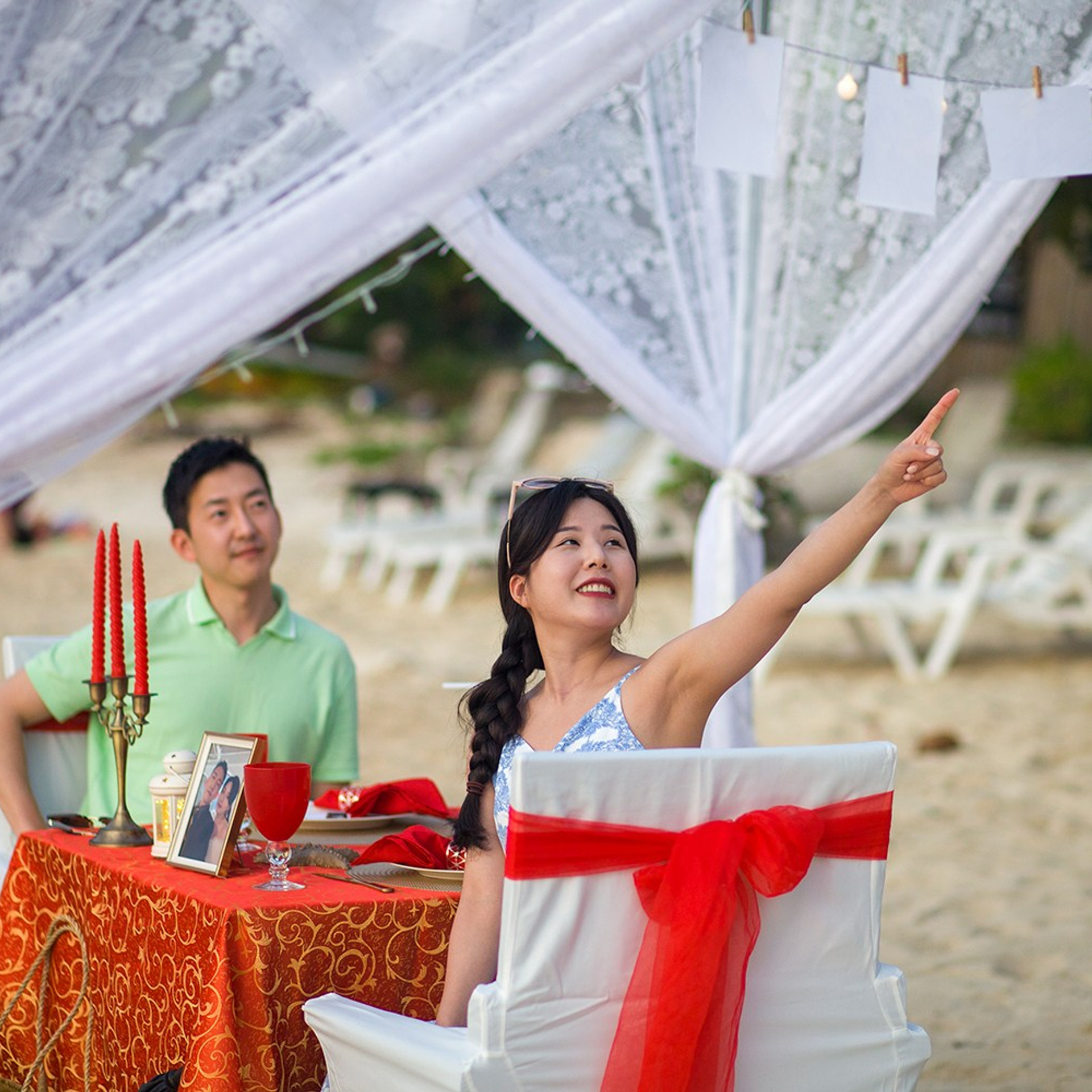 Romantic beach proposal setup in Koh Samui with candles and flower arch.