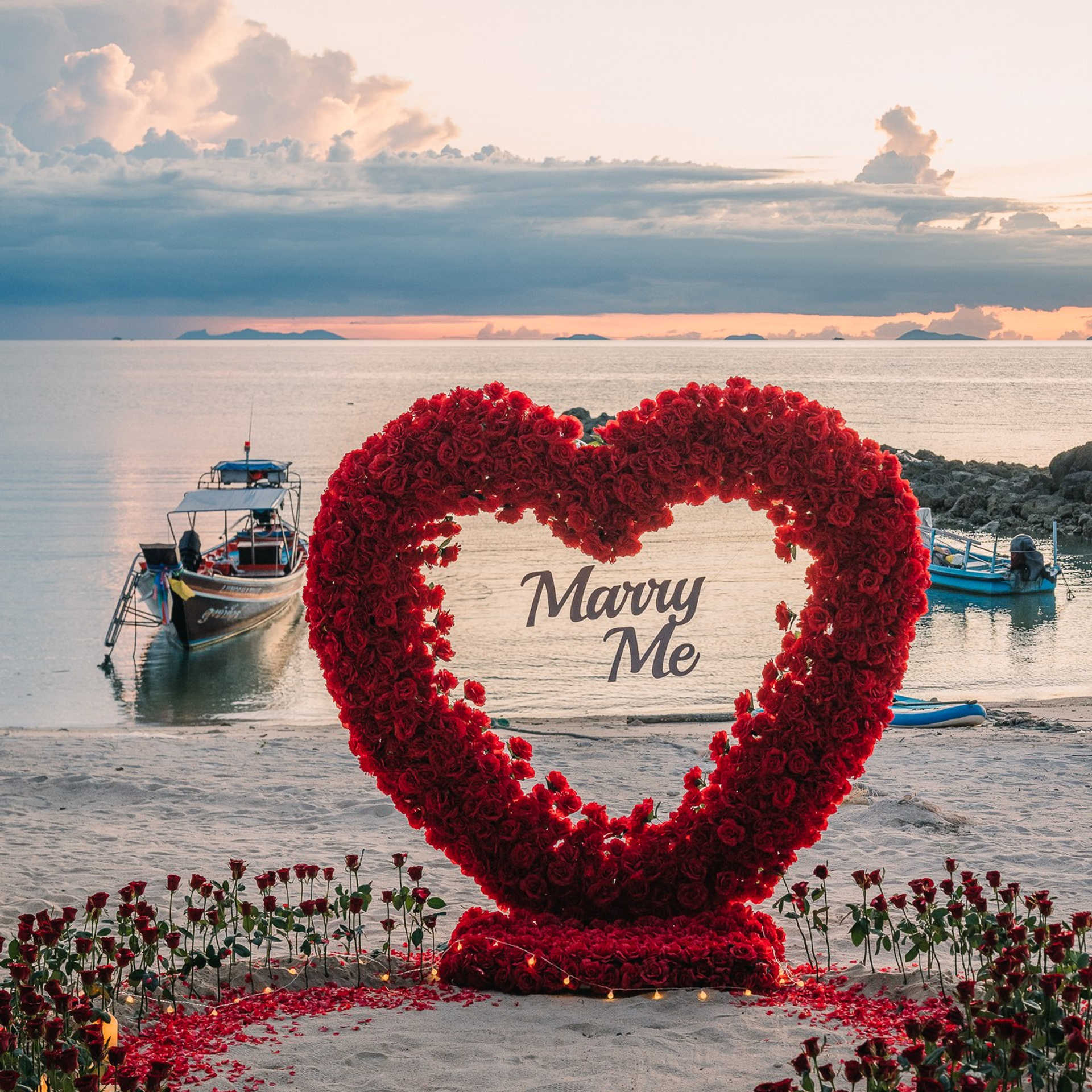 Romantic beach proposal setup in Koh Samui with candles and flower arch.