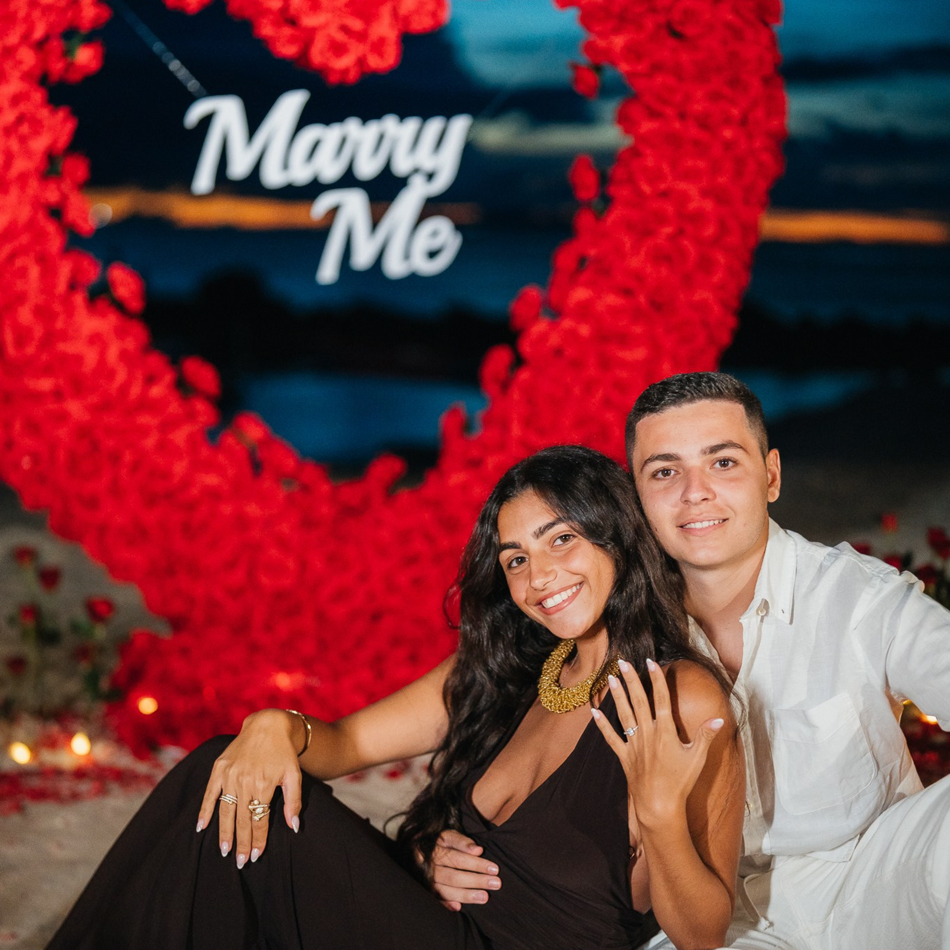 Romantic beach proposal setup in Koh Samui with candles and flower arch.