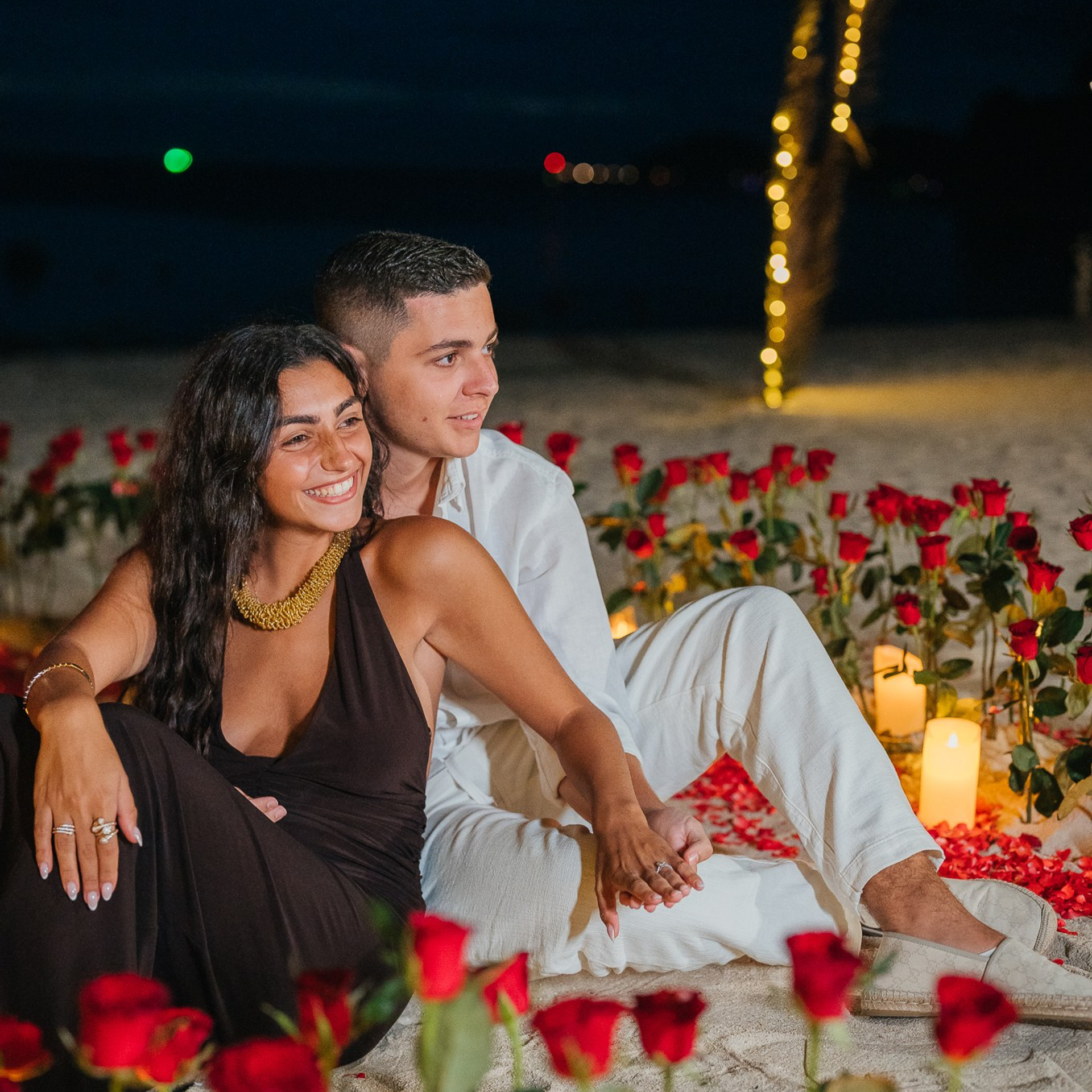 Romantic beach proposal setup in Koh Samui with candles and flower arch.