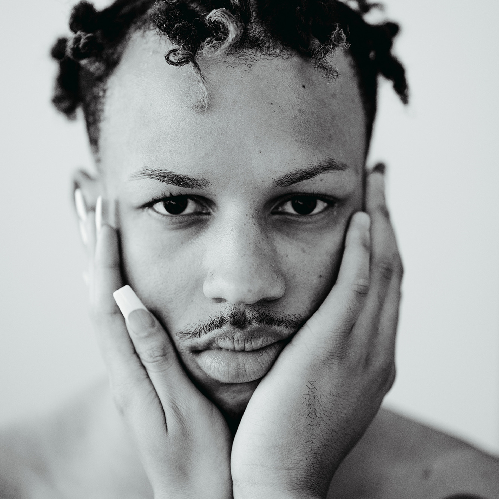 Black and white portrait of young man resting chin on hands - portrait photographer Mexico City