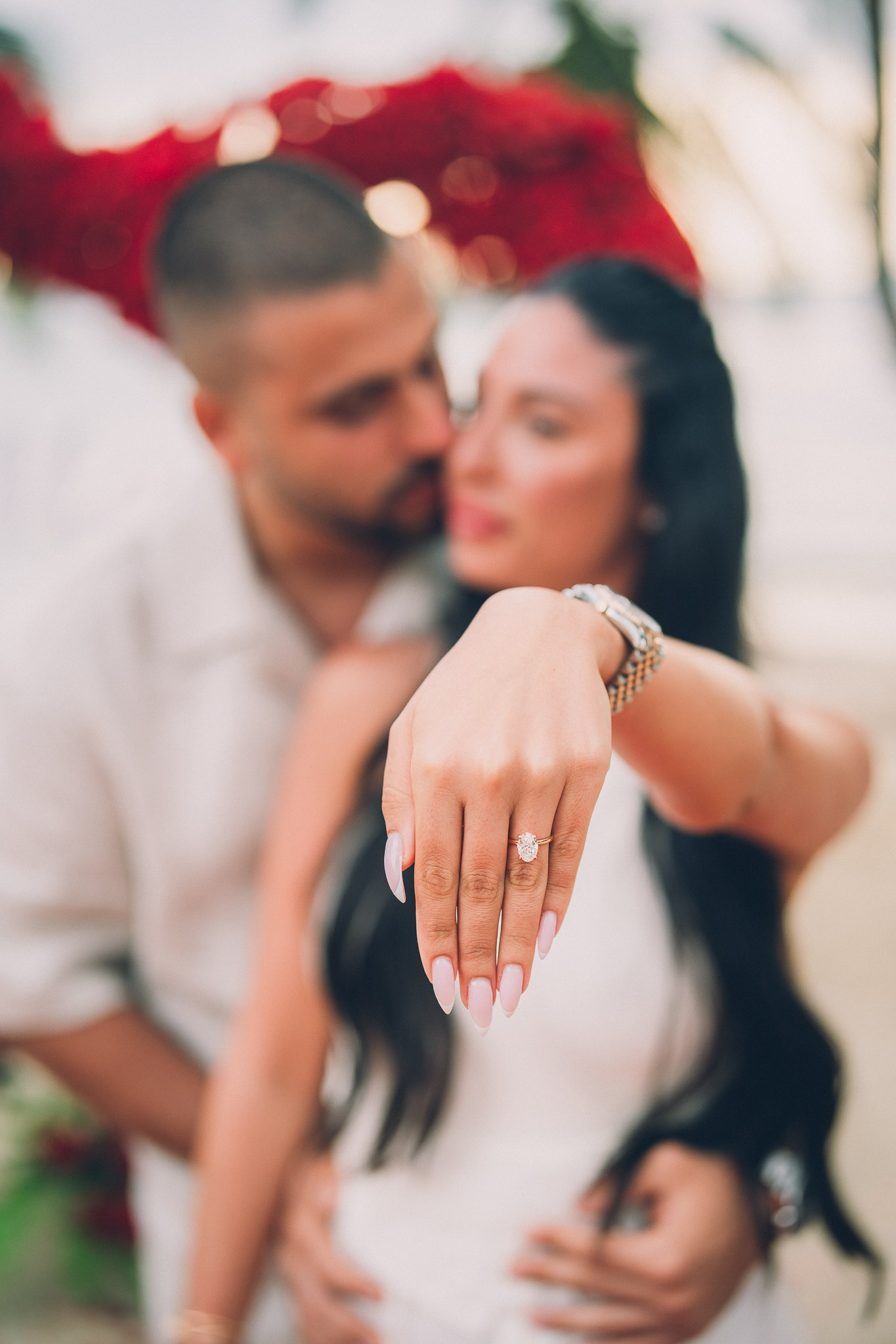 Close-up of a newly engaged woman showing her engagement ring while embracing her partner in Pattaya.