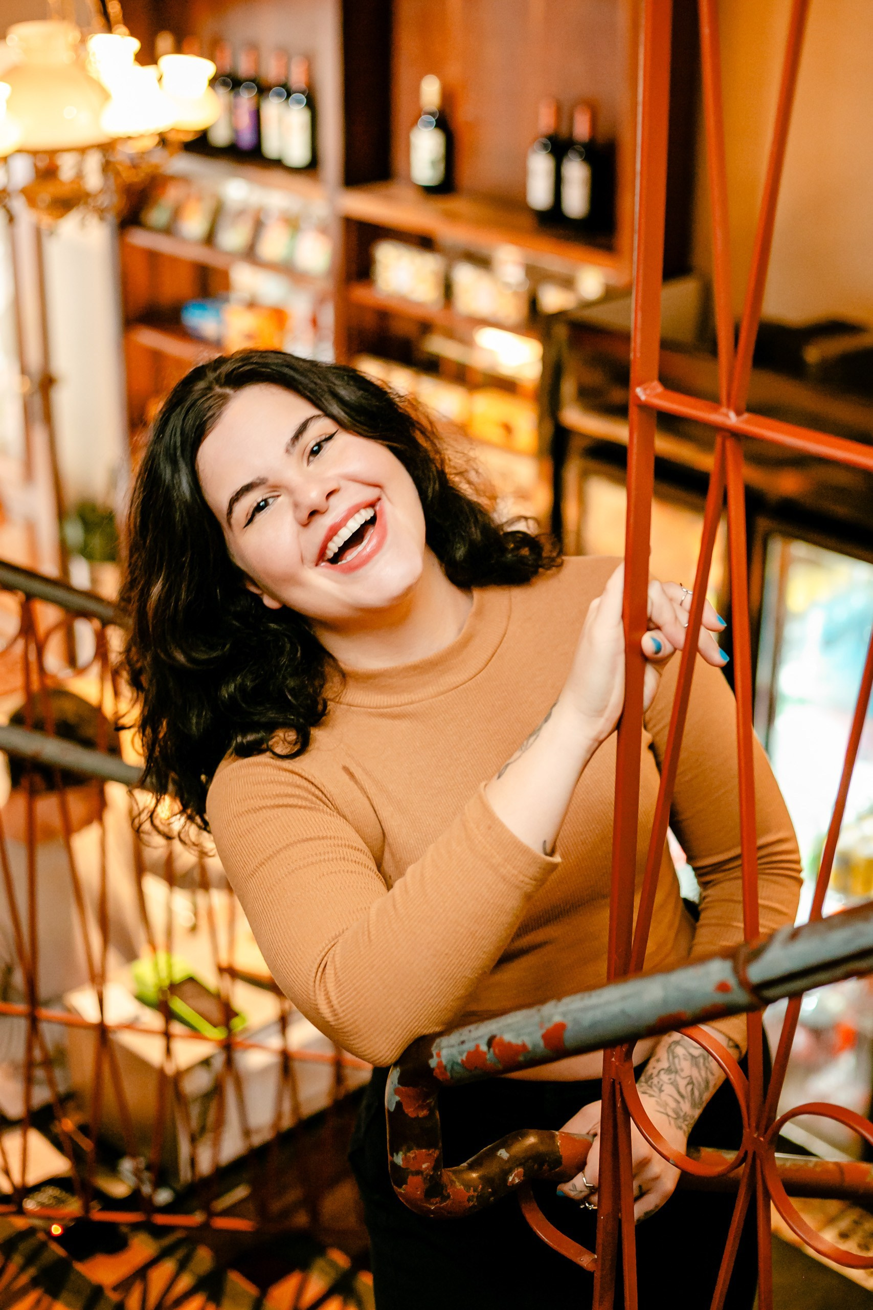 Mulher sorrindo para a câmera com fundo de cafeteria.