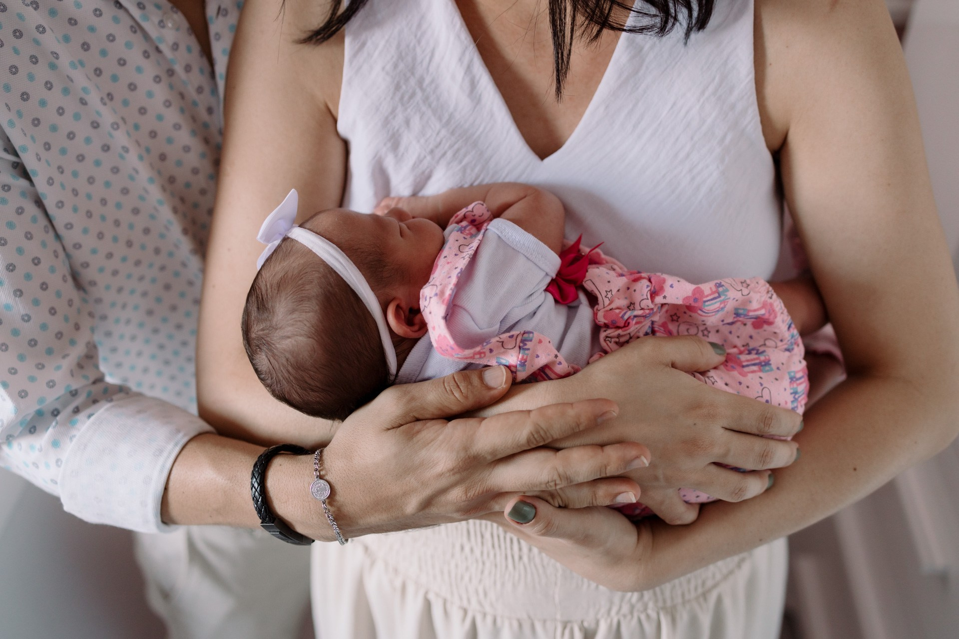 Ensaio recém-nascido com bebê nos braços dos pais