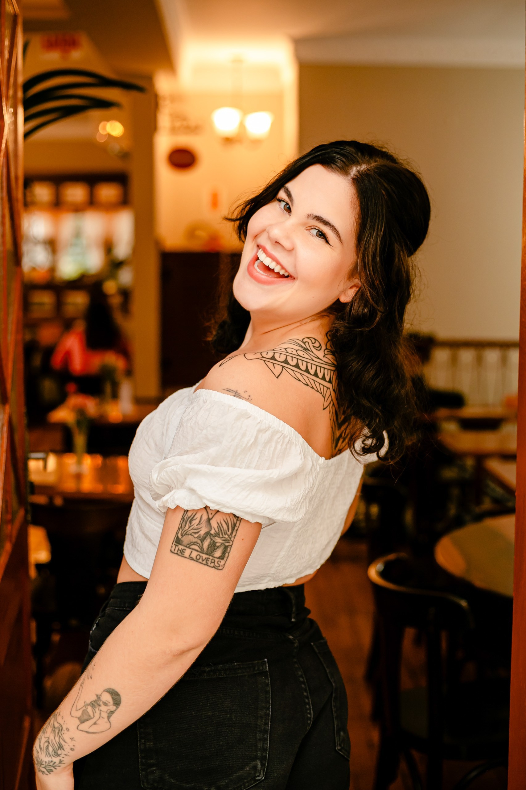 Mulher de costas olhando pra trás com fundo de cafeteria.